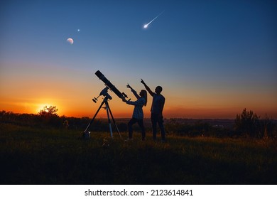 Couple Stargazing Together With A Astronomical Telescope.