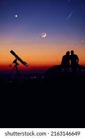 Couple Stargazing Together With A Astronomical Telescope.