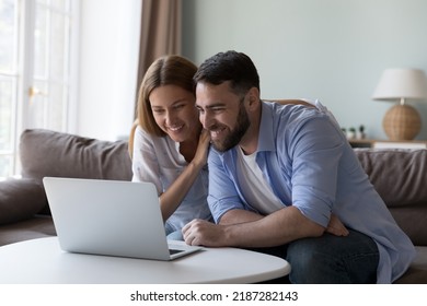 Couple staring at laptop screen smile enjoy good news, reading received notification feel satisfied spend time using modern device. Wireless technology, marketplace on-line, e-shopping at home
