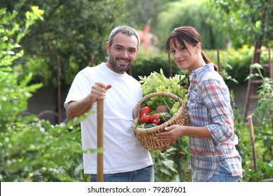 Couple Stood In Garden With Vegetables