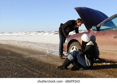 A Couple Are Stranded At Side Of Highway With A Car Breakdown In Winter.