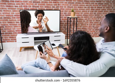 Couple Streaming Movie From Tablet To TV Using Wireless Connection