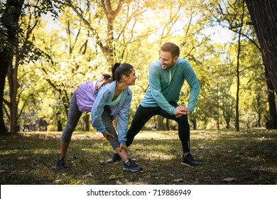 Couple Stretching In Park. Young Couple Working Exercise Together.