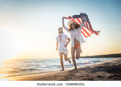 Couple strolling at the beach and smiling - Young adults enjoying summer holidays on a tropical island - Powered by Shutterstock