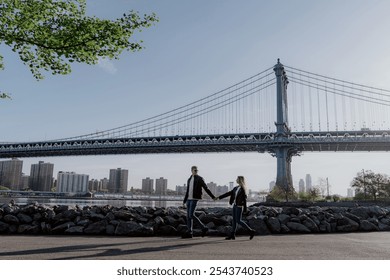 As a couple strolls hand in hand near the iconic Manhattan Bridge, they capture the essence of love and urban beauty in New York. - Powered by Shutterstock