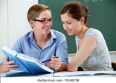 couple of students in a classroom doing homework