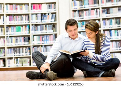 Couple Of Students At The Library Reading A Book