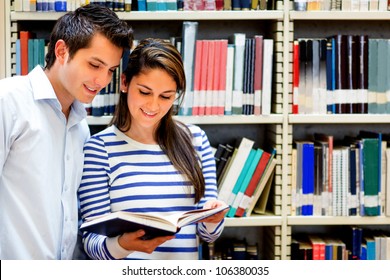 Couple Of Students At The Library Reading A Book