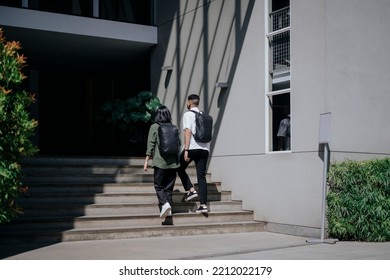 A Couple Students Using Black Backpack Walk Up The Stairs To Enter The Building