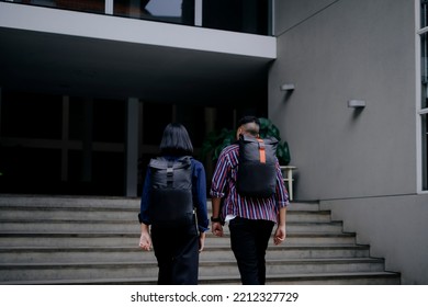 A Couple Students Using Black Backpack Walk Up The Stairs To Enter The Building