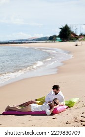 Couple Sunbathing On The Beach