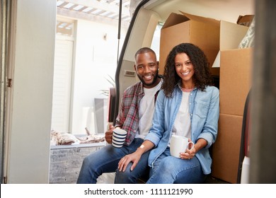 Couple Taking A Break In Back Of Removal Truck On Moving Day