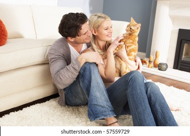 Couple Taking Playing With Pet Cat At Home