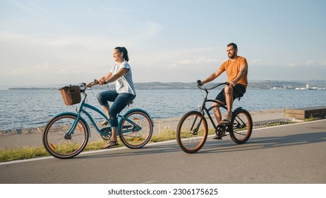 Couple taking pleasure in the ride on beach cruiser bikes, pedaling on a wonderful route near the sea - Powered by Shutterstock