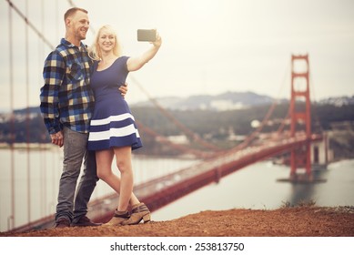 Couple In Taking Selfie In Front Of Golden Gate Bridge