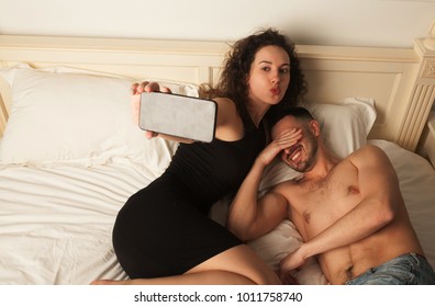 Couple Taking Selfie. Happy Couple Taking Photo.woman In Black Dress. Couple In Bed. Man Is Embarrassed. Funny Faces 