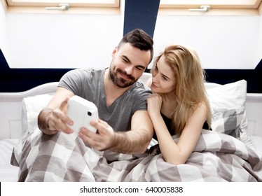 Couple Taking Selfie With Instant Camera At Home.