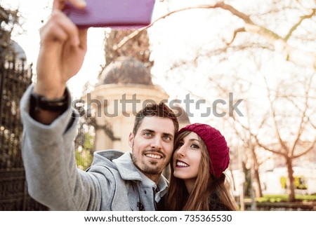 Similar – couple taking selfie in the street