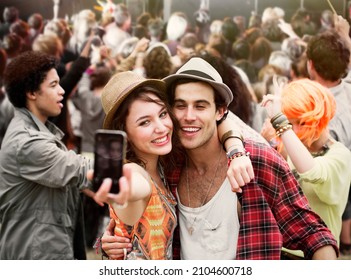 Couple taking self-portrait at music festival - Powered by Shutterstock