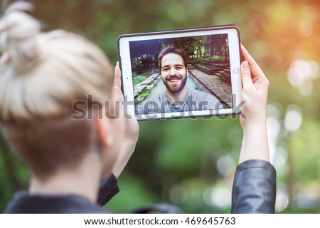 a couple talking over a video call, by using a tablet.