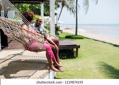 Couple talking and sitting on a hammock - Powered by Shutterstock