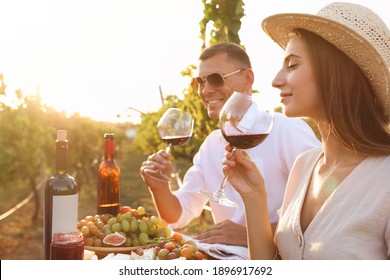 Couple tasting red wine at vineyard on sunny day - Powered by Shutterstock