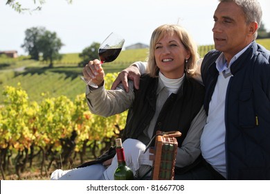 Couple Tasting Wine In Vineyard