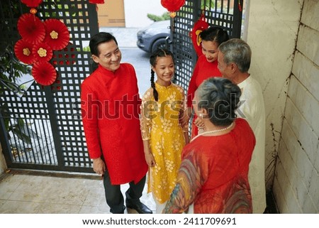 Couple with teenage girl visiting senior parents for Chinese New Year