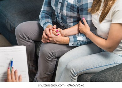 Couple In Therapy Or Marriage Counseling. Man And Woman Holding Hands On Couch During A Psychotherapy Session. Psychologist, Counselor, Therapist, Psychiatrist Or Relationship Consultant Giving Advice