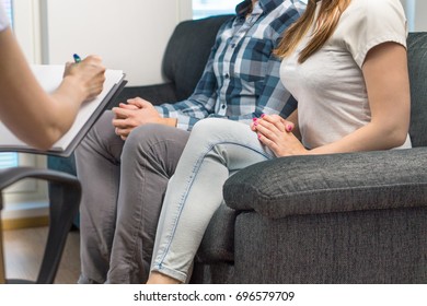 Couple in therapy or marriage counseling. Psychologist, counselor, therapist, psychiatrist or relationship consultant giving advice. Man and woman sitting on couch during a psychotherapy session. 