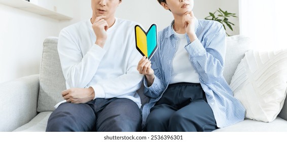 A couple thinking while holding a beginner's mark