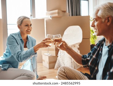 Couple, toast and moving in new house with boxes, champagne and relax on floor for celebration and success. Mature people with wine glasses, cheers and excited for home with mortgage and real estate - Powered by Shutterstock