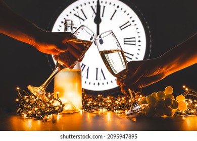 Couple Toast To The New Year With Two Glasses Of Champagne. Celebrating New Year's Eve. Lucky Grapes. Spanish Tradition In Which 12 Grapes Are Eaten With The Last 12 Chimes Of The Year.