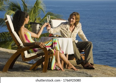 Couple Toasting Champagne Overlooking Beach