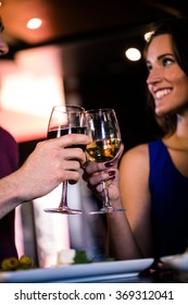 Couple toasting with a glass of wine in a bar