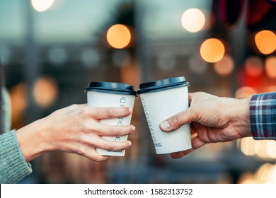 a couple is toasting with paper cup and drink coffee - Powered by Shutterstock