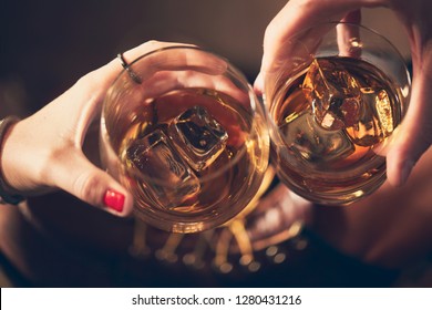 A Couple Toasting With Whiskey In A Bar