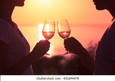 Couple Toasting Wine Glasses In Romantic Date Setting.