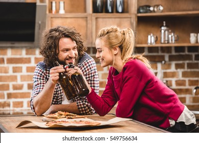 Couple together at kitchen, toasting with beer - Powered by Shutterstock