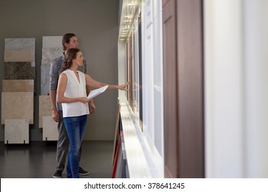 Couple Touching Different Finishes In Modern Kitchen Shop Showroom While Planning Their Dream Kitchen