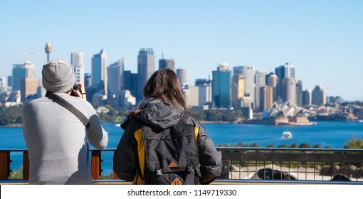 Couple of tourism stand on view point in Sydney zoo for take a photo to Sydney harbour, city and bridge, Sydney, New south wales, Australia