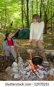 Couple Of Tourist Cooking Of Fire In Camp Place