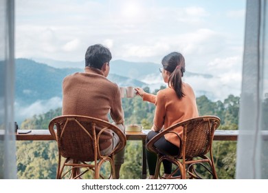 Couple tourist drinking coffee and eating breakfast against mountain view at countryside home or homestay in the morning. Vacation, together travel, honeymoon, blogger, journey and trip concept