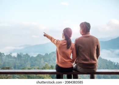 Couple Tourist Relaxing And Looking Mountain View At Countryside Home Or Homestay In The Morning. Vacation, Together Travel, Honeymoon, Blogger, Journey, Trip And Relaxing Concept