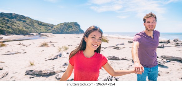 Couple Tourists Walking On Ship Creek Beach On Summer Travel Vacation In West Coast, South Island Of New Zealand Panoramic. Asian Woman, Caucasian Man