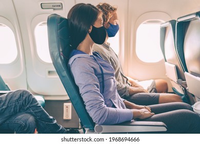 Couple tourists wearing face masks on travel vacation flight inside plane. Coronavirus safety prevention for passengers of flight. People lifestyle.