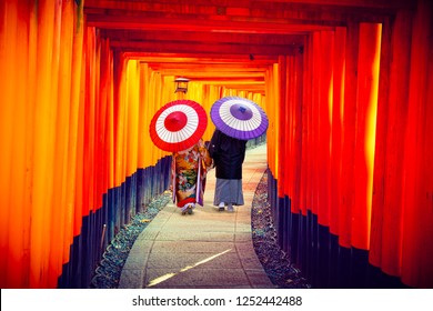 Couple in traditional japanese kimonos walking at Fushimi Inari Shrine in Kyoto, Japan - Powered by Shutterstock