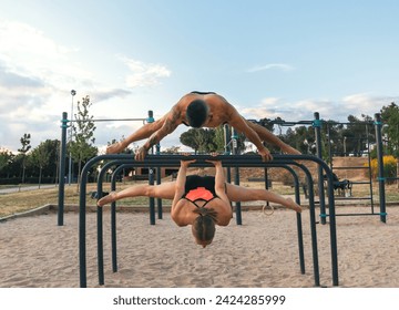 couple training together in a calisthenics park. doing back lever and straddle planche. - Powered by Shutterstock