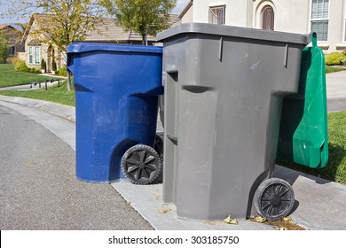 Couple Of Trash Bins Awaits Pickup Off A Residential Street.