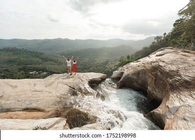 Couple of  travel bloggers explore beautiful places in Sri Lanka island. Young  torist couple  standing on the top of  Diyaluma waterfall in Sri Lanka. Adventure traveler exploring the world